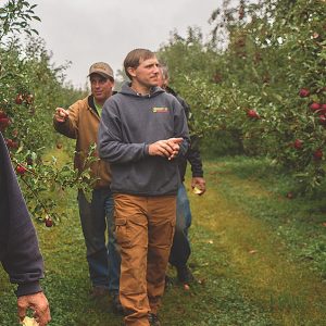 Farmers walking in orchard - Five Acre Farms